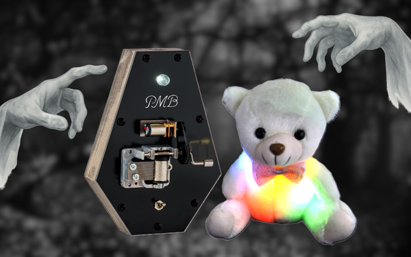 Hands reaching for a teddy pod and a coffin shaped music box
