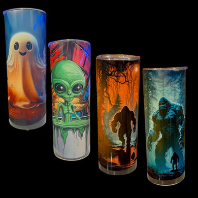 Four tall cylindrical tumblers with clear bottoms, each featuring a different spooky or fantasy graphic print, displayed against a solid black background.