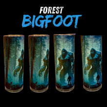 Four tall cylindrical tumblers with a printed 'Forest Bigfoot' design, shown against a black background with the words 'FOREST BIGFOOT' above them. The tumblers feature an illustration of a Bigfoot figure in a misty blue-green forest with a small human silhouette.